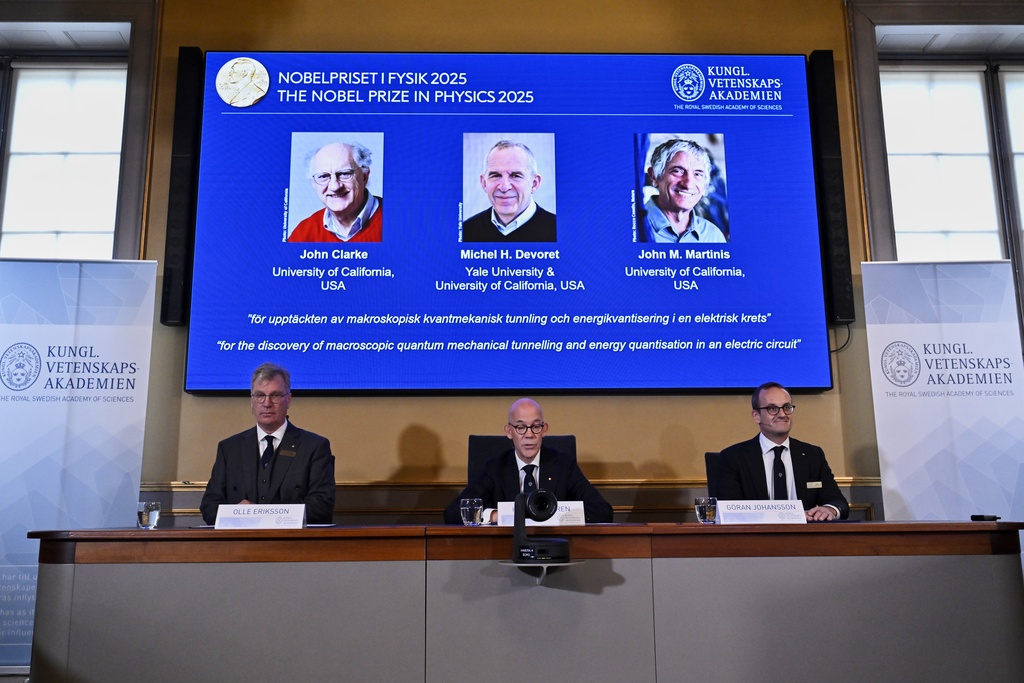 From left, Chair of the Nobel Committee for Physics Chair Olle Eriksson, Secretary General of the Swedish Academy of Sciences Hans Ellegren and Member of the Nobel Committee for Physics Goran Johansson announce Tuesday that John Clarke, Michel H Devoret and John M. Martinis, on screen behind, are the recipients the Nobel Prize in Physics.